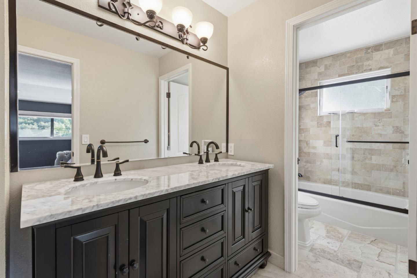 15965 Shannon Road Los Gatos, CA 95032 - Photo 20 of 53 a bathroom with a granite countertop sink a mirror and a shower