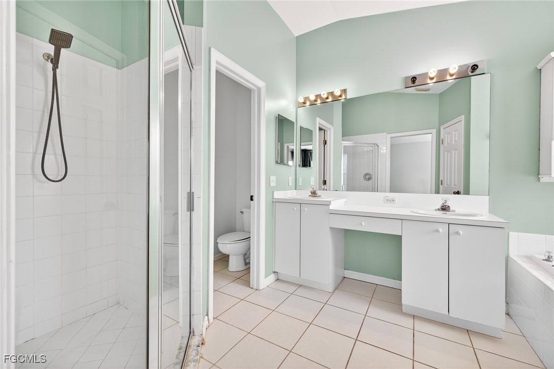 4664 Varsity Circle Lehigh Acres, FL 33971 - Photo 14 of 31 a bathroom with a double vanity sink mirror and toilet