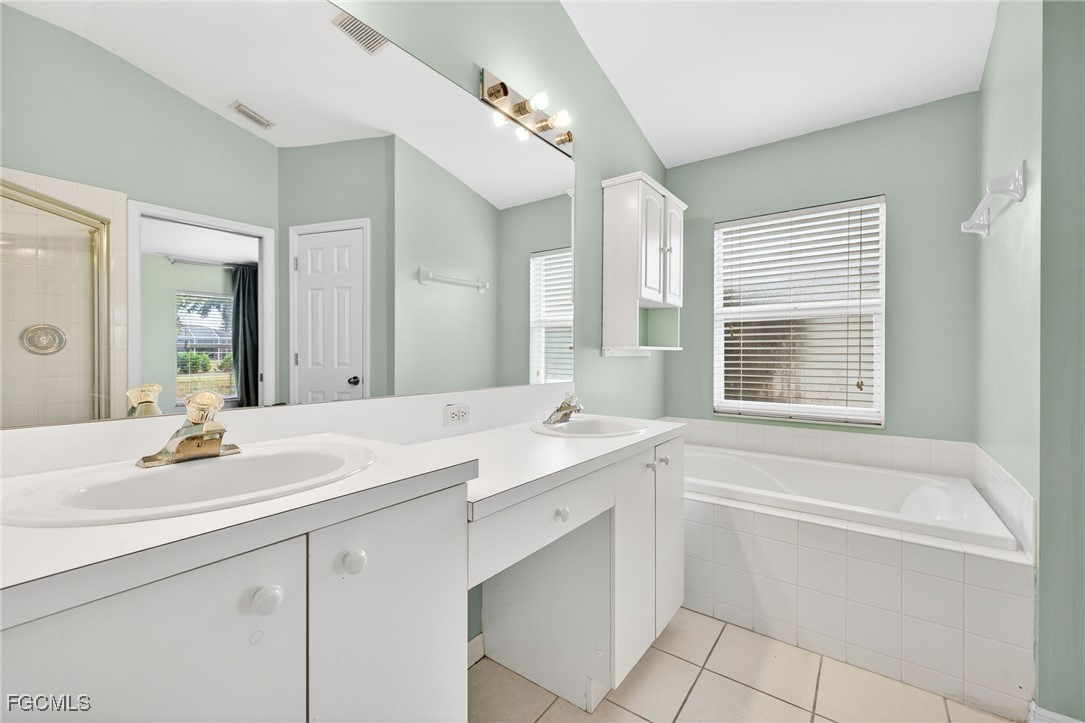 4664 Varsity Circle Lehigh Acres, FL 33971 - Photo 15 of 31 a bathroom with a sink double vanity mirror and a bathtub