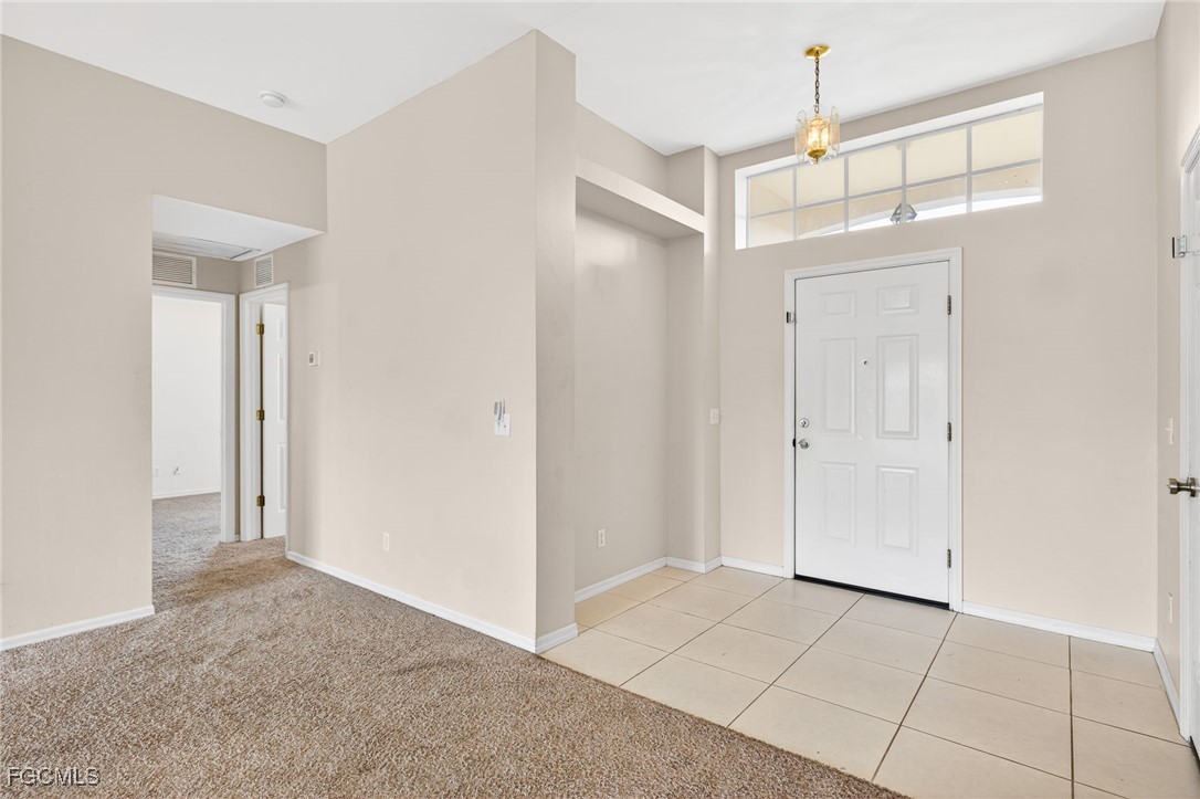 4664 Varsity Circle Lehigh Acres, FL 33971 - Photo 27 of 31 a view of a hallway with closet and chandelier fan