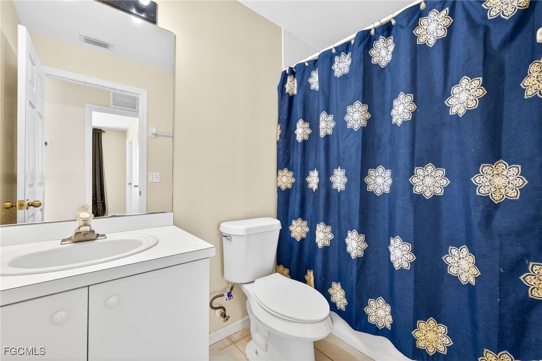 4664 Varsity Circle Lehigh Acres, FL 33971 - Photo 9 of 31 a bathroom with a toilet sink and mirror