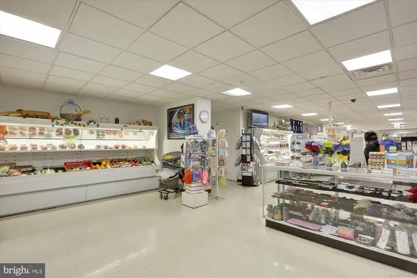 a view of a hallway with wooden floor and cabinet