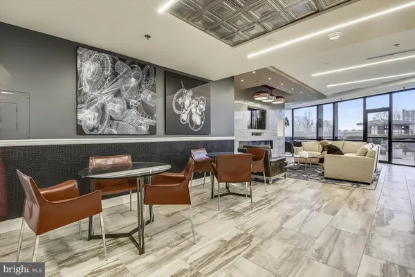 a dining room with furniture and a large window