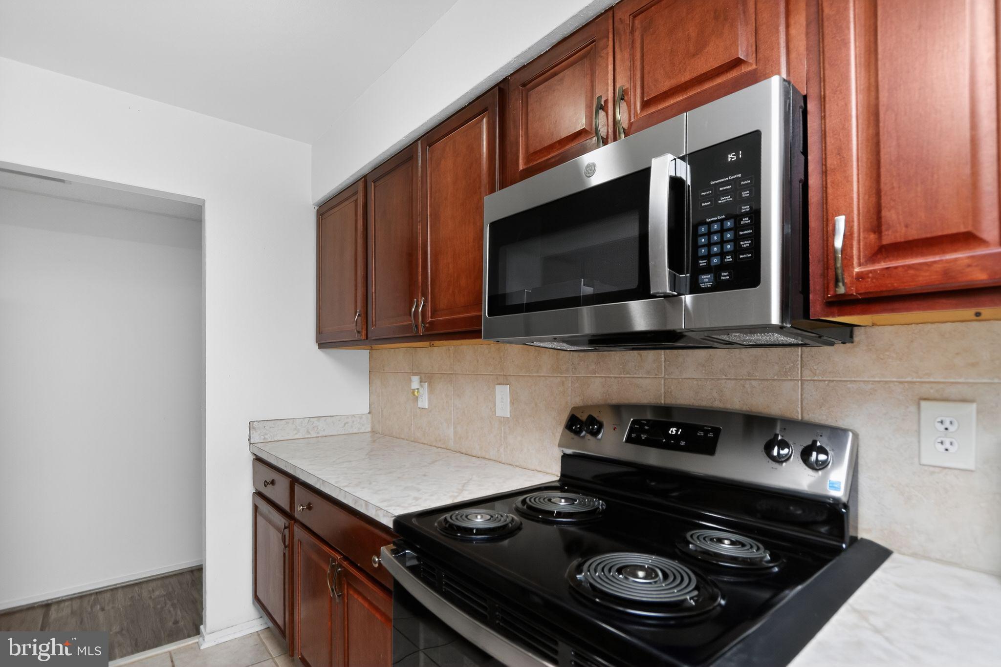 6101 Edsall Road, Unit 1704 Alexandria, VA 22304 - Photo 15 of 33 a kitchen with a stove and a microwave