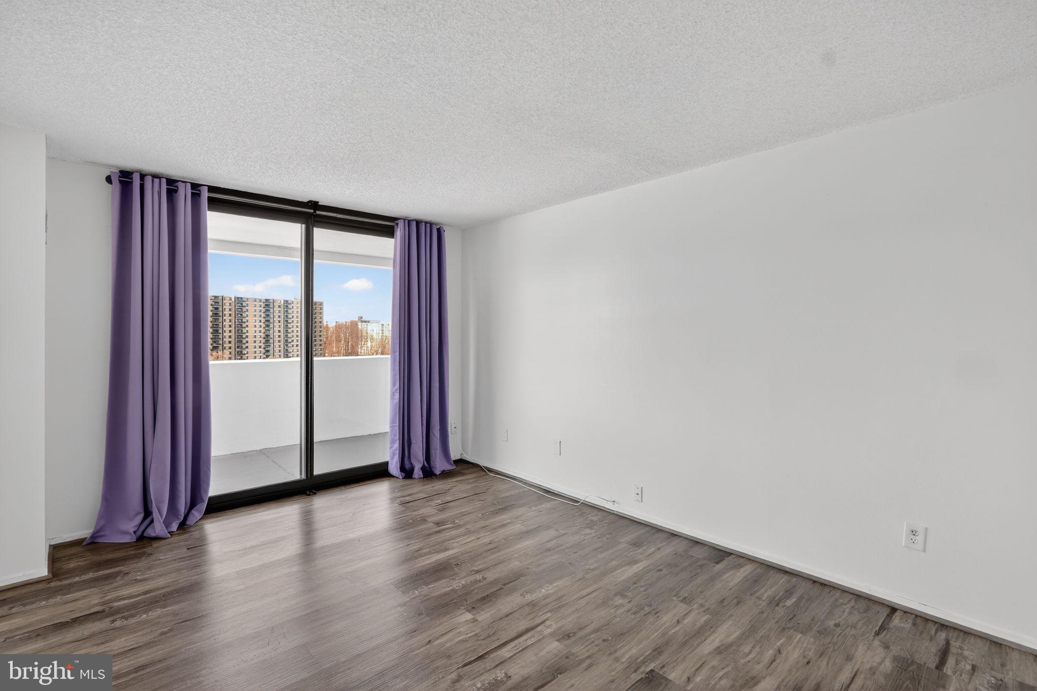 6101 Edsall Road, Unit 1704 Alexandria, VA 22304 - Photo 19 of 33 a view of an empty room with wooden floor and a window
