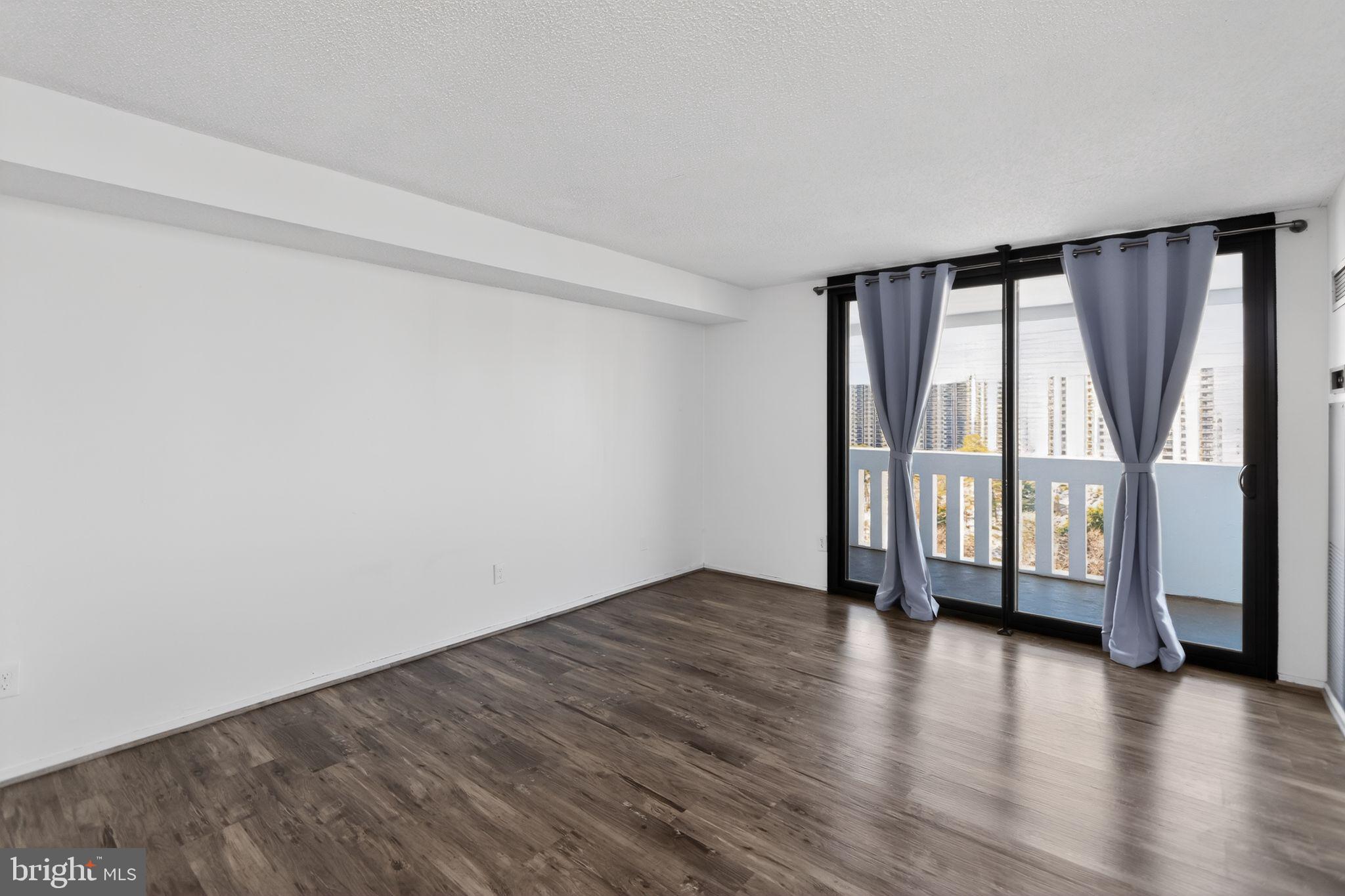6101 Edsall Road, Unit 1704 Alexandria, VA 22304 - Photo 25 of 33 an empty room with wooden floor and a window