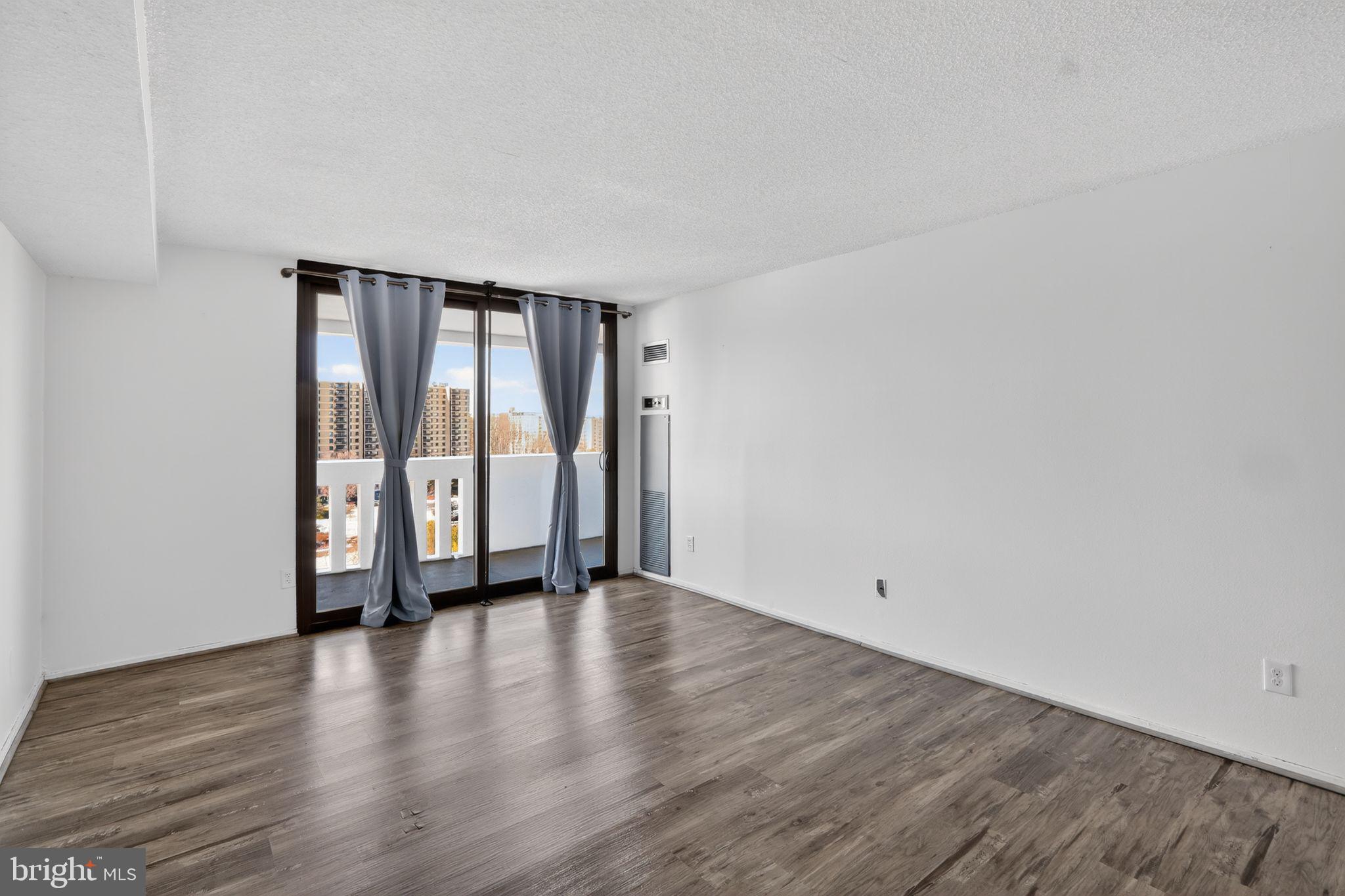 6101 Edsall Road, Unit 1704 Alexandria, VA 22304 - Photo 26 of 33 a view of an empty room with wooden floor and glass door