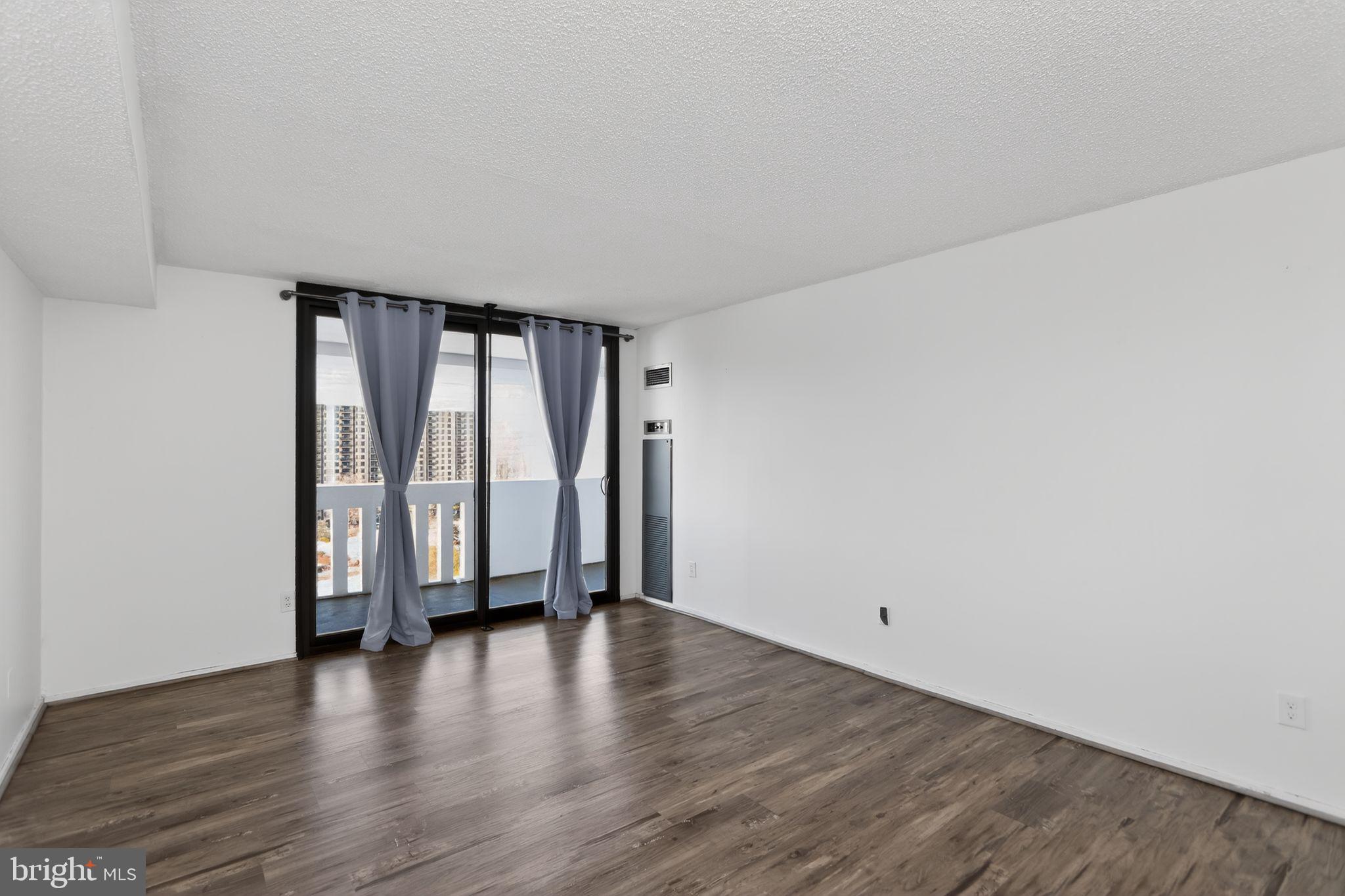 6101 Edsall Road, Unit 1704 Alexandria, VA 22304 - Photo 27 of 33 a view of an empty room with wooden floor and a window