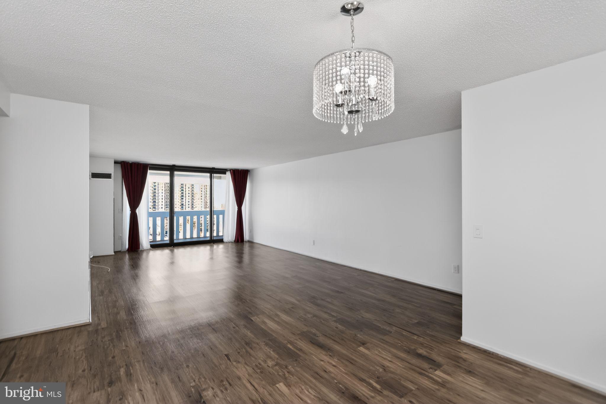 6101 Edsall Road, Unit 1704 Alexandria, VA 22304 - Photo 6 of 33 a view of an empty room with wooden floor and a window