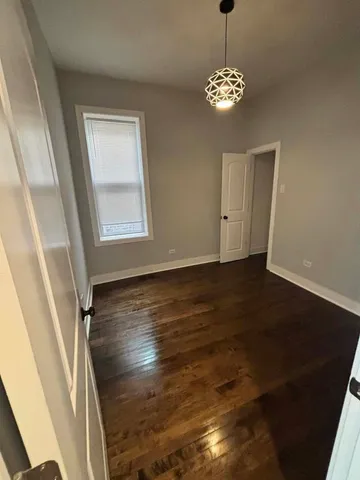 a view of a room with wooden floor and chandelier