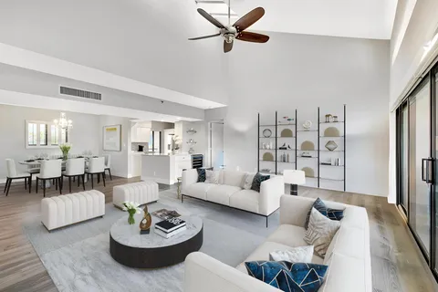 a living room with furniture kitchen view and a window