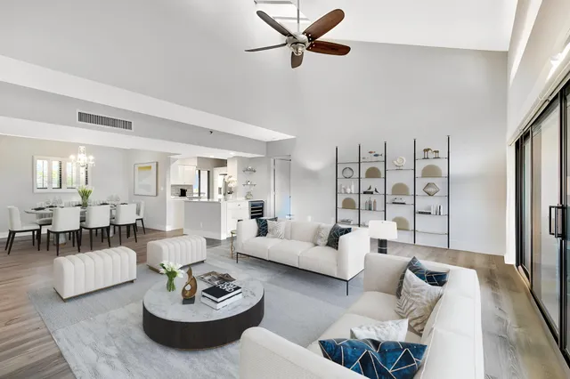 a living room with furniture kitchen view and a window