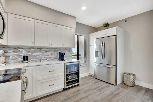 a kitchen with appliances a refrigerator and a sink