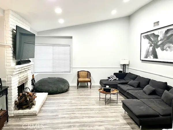 a living room with furniture a fireplace and a flat screen tv