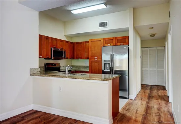 a kitchen with kitchen island granite countertop a sink stove and refrigerator