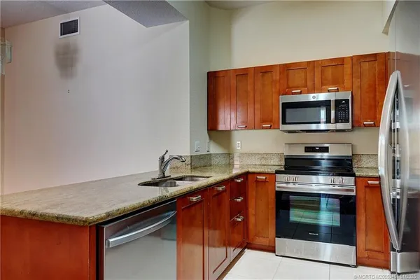a kitchen with granite countertop a sink and a large mirror