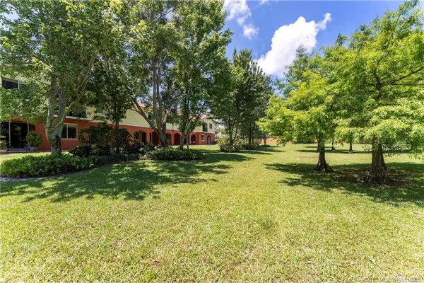 a backyard of a house with lots of green space and fountain