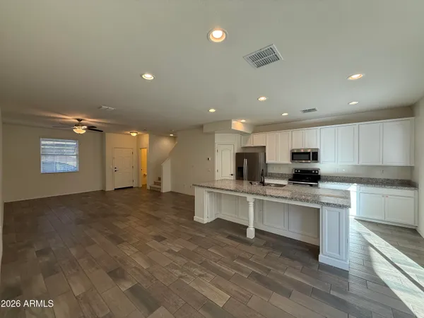 a kitchen with stainless steel appliances a sink stove refrigerator and cabinets