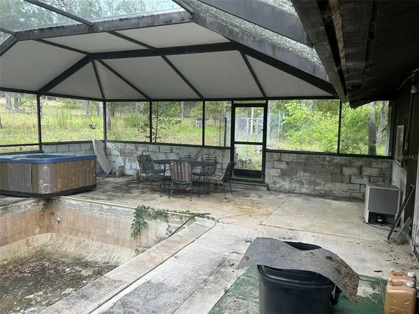 a backyard of a house with table and chairs under an umbrella