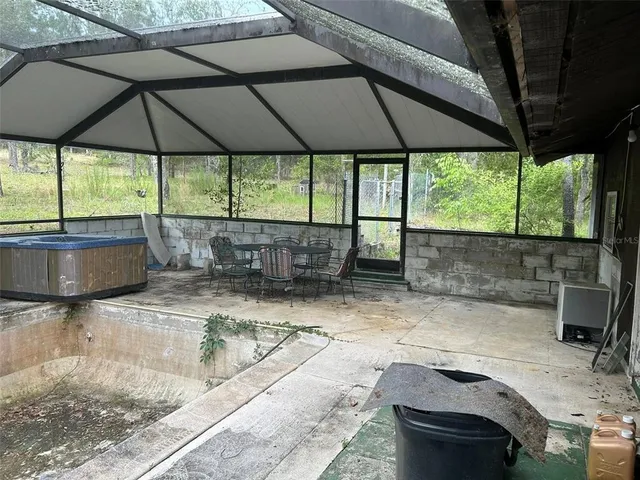 a backyard of a house with table and chairs under an umbrella