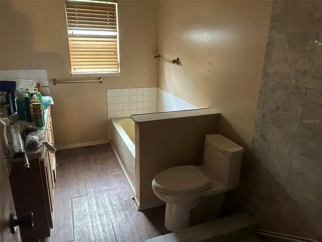 a bathroom with a toilet a sink and a window