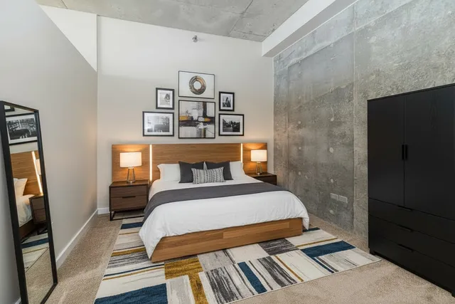 a bedroom with a bed and painting on the wall