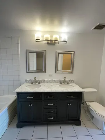a bathroom with a double vanity sink and a mirror