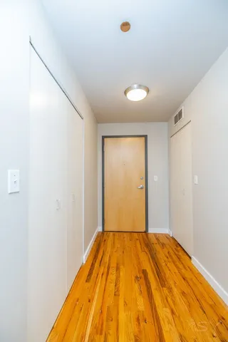 a view of a room with a window and wooden floor