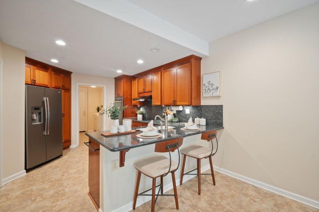 a dining hall with stainless steel appliances granite countertop a granite counter tops and a view of living room