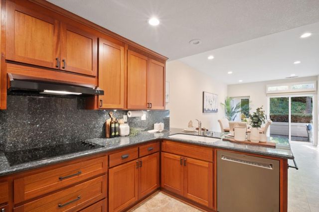 a kitchen with stainless steel appliances granite countertop wooden cabinets a sink and dishwasher
