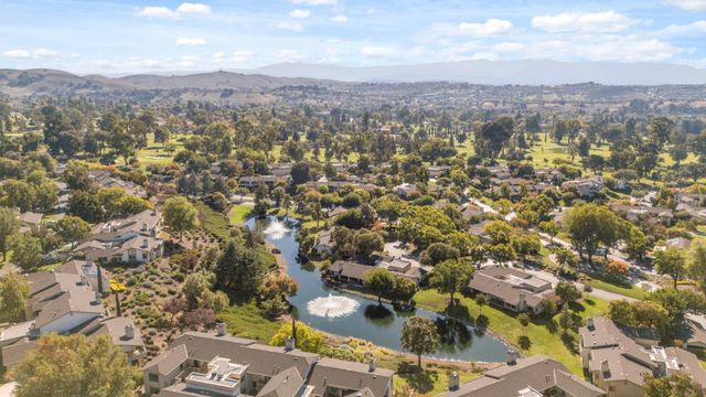 an aerial view of residential house with yard and mountain view in back
