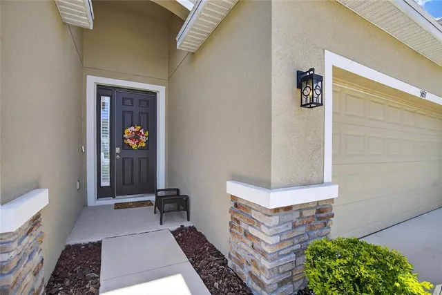 a living room with furniture and a large window with kitchen view