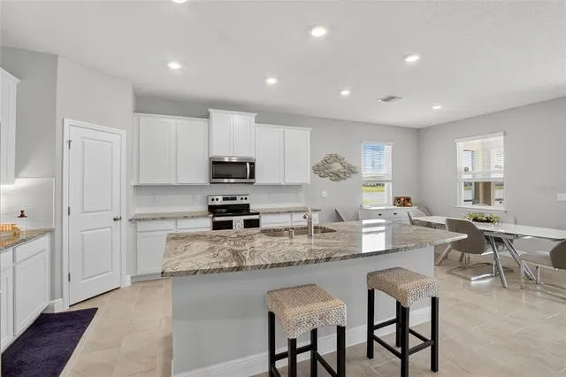a living room with furniture kitchen view and a fireplace