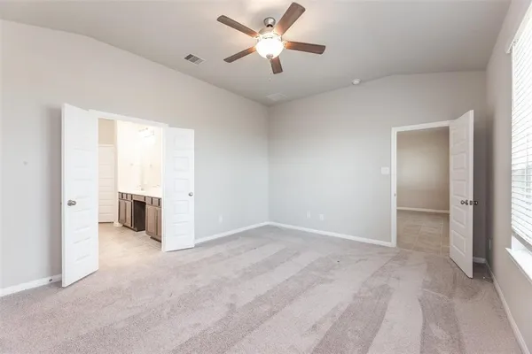 an empty room with closet and a ceiling fan