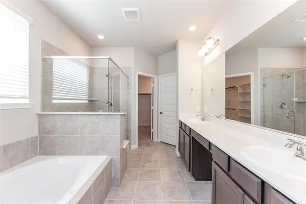a bathroom with a tub a sink and mirror