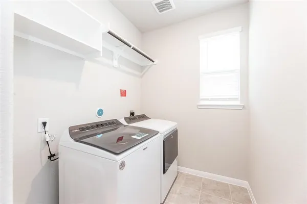 a view of a kitchen with refrigerator and white wall