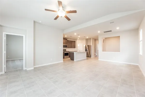 a view of an empty room with a kitchen