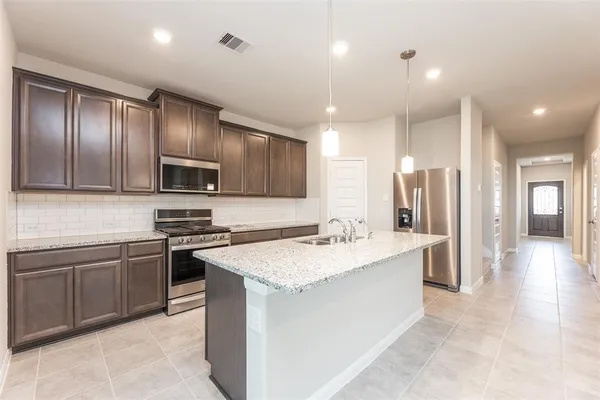 a large kitchen with stainless steel appliances lots of counter space and wooden floor