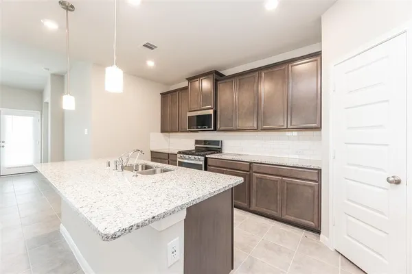 a kitchen with a sink refrigerator and microwave