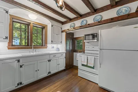 a kitchen with granite countertop white cabinets and white appliances