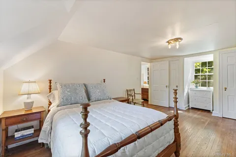 a bedroom with a large bed and wooden floor