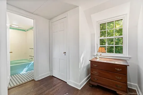 an empty room with a window and wooden floor