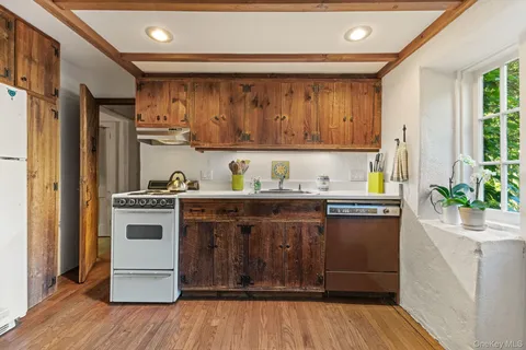 a kitchen with stainless steel appliances granite countertop a sink a counter space and a window