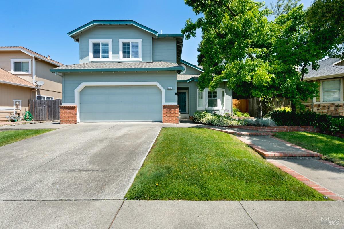 a front view of a house with a yard and trees