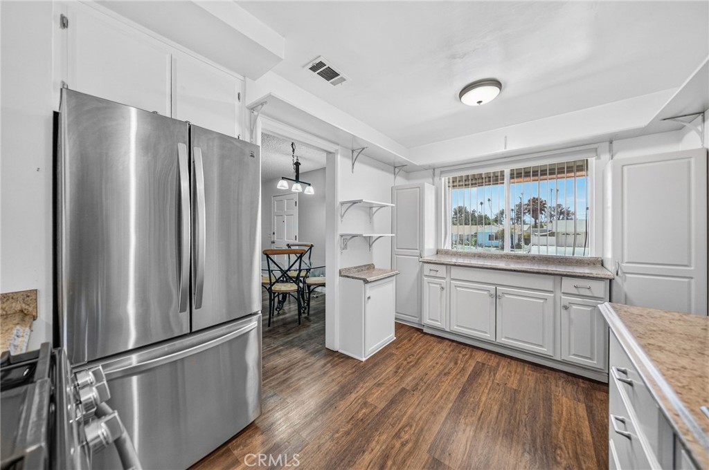 29078 Bradley Road Menifee, CA 92586 - Photo 18 of 42 a kitchen with a refrigerator and wooden floor