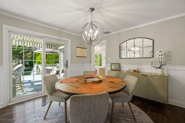 a dining room with furniture a chandelier and wooden floor