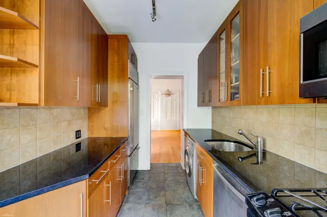 a kitchen with a sink a counter top space and cabinets