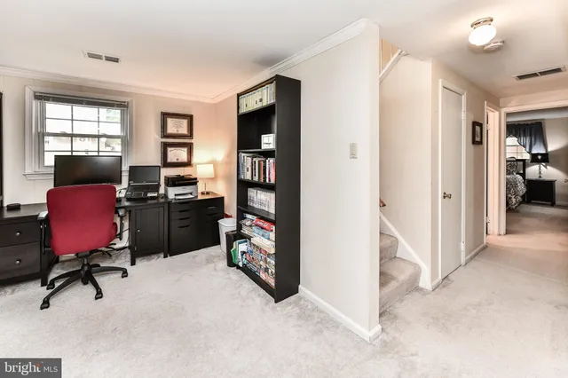 a view of a workspace with furniture and a window