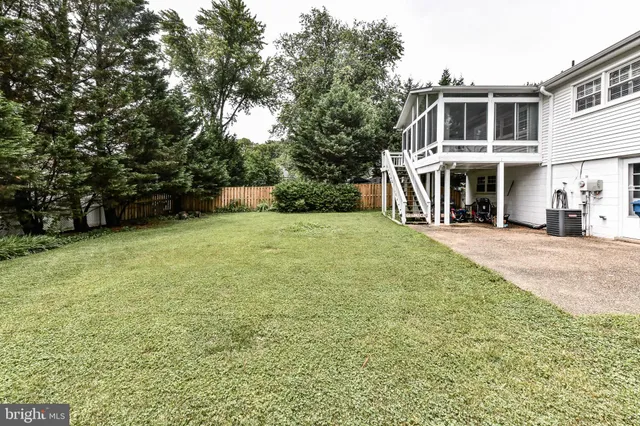 a view of a house with a big yard and large trees