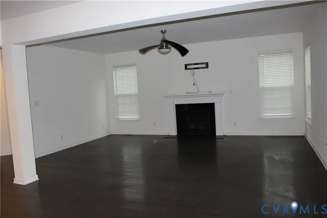 a view of empty room with wooden floor and fireplace